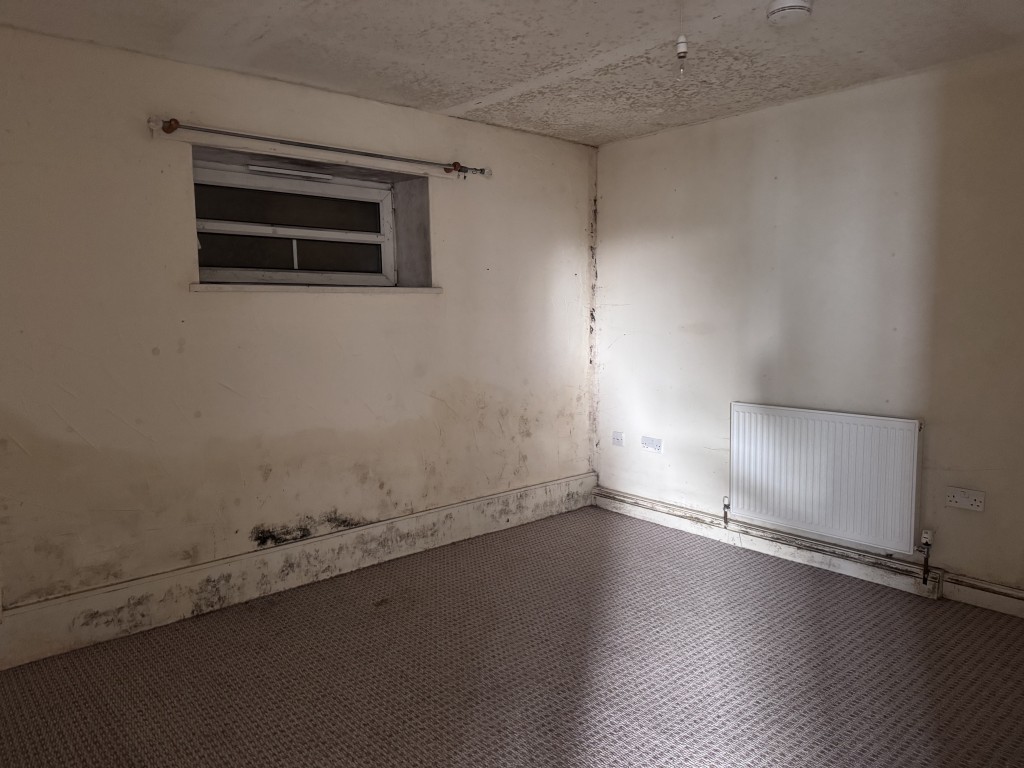 Lot: 9 - TOWN CENTRE BUILDING ARRANGED AS THIRTEEN FLATS IN NEED OF SIGNIFICANT IMPROVEMENT - Poor condition flat bedroom